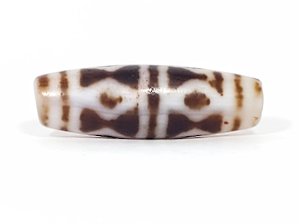 At-082524-DS antique diamond spear agate dzi 40.5x13.1mm angled view abrupt taper end cream-white drill hole unretouched