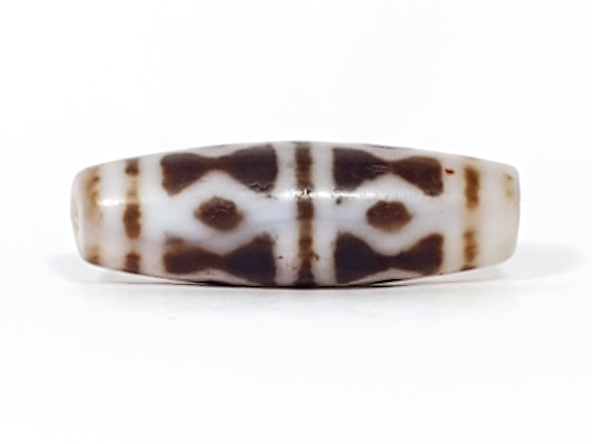 At-082524-DS antique diamond spear agate dzi 40.5x13.1mm angled view gradual taper end cream-white drill hole unretouched