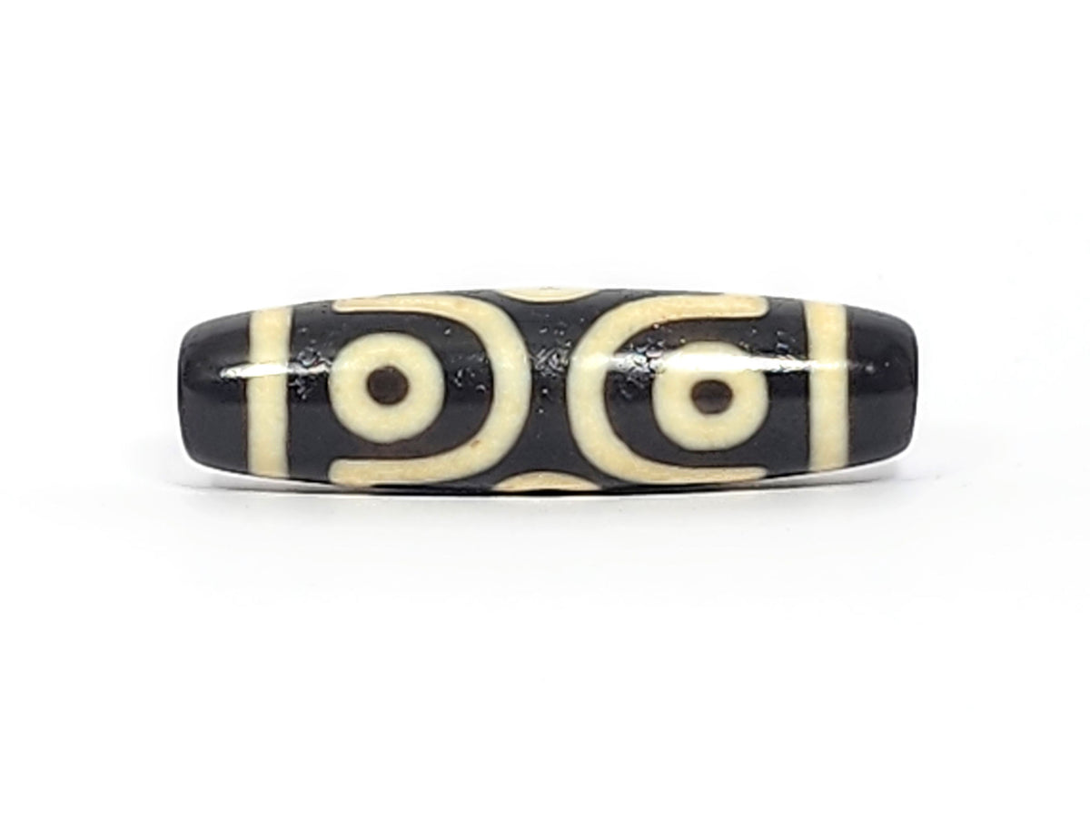 Face B of antique six eye dzi At-042925-6E2, single concentric-ring eye within diamond star frame on pitch-black agate, bright white cream, 41.4mm, unretouched photography