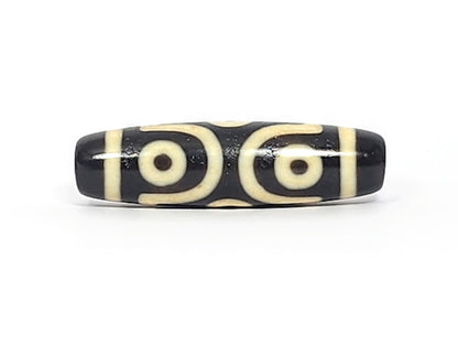 Face B of antique six eye dzi At-042925-6E2, single concentric-ring eye within diamond star frame on pitch-black agate, bright white cream, 41.4mm, unretouched photography