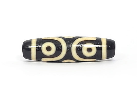 Face B of antique six eye dzi At-042925-6E2, single concentric-ring eye within diamond star frame on pitch-black agate, bright white cream, 41.4mm, unretouched photography