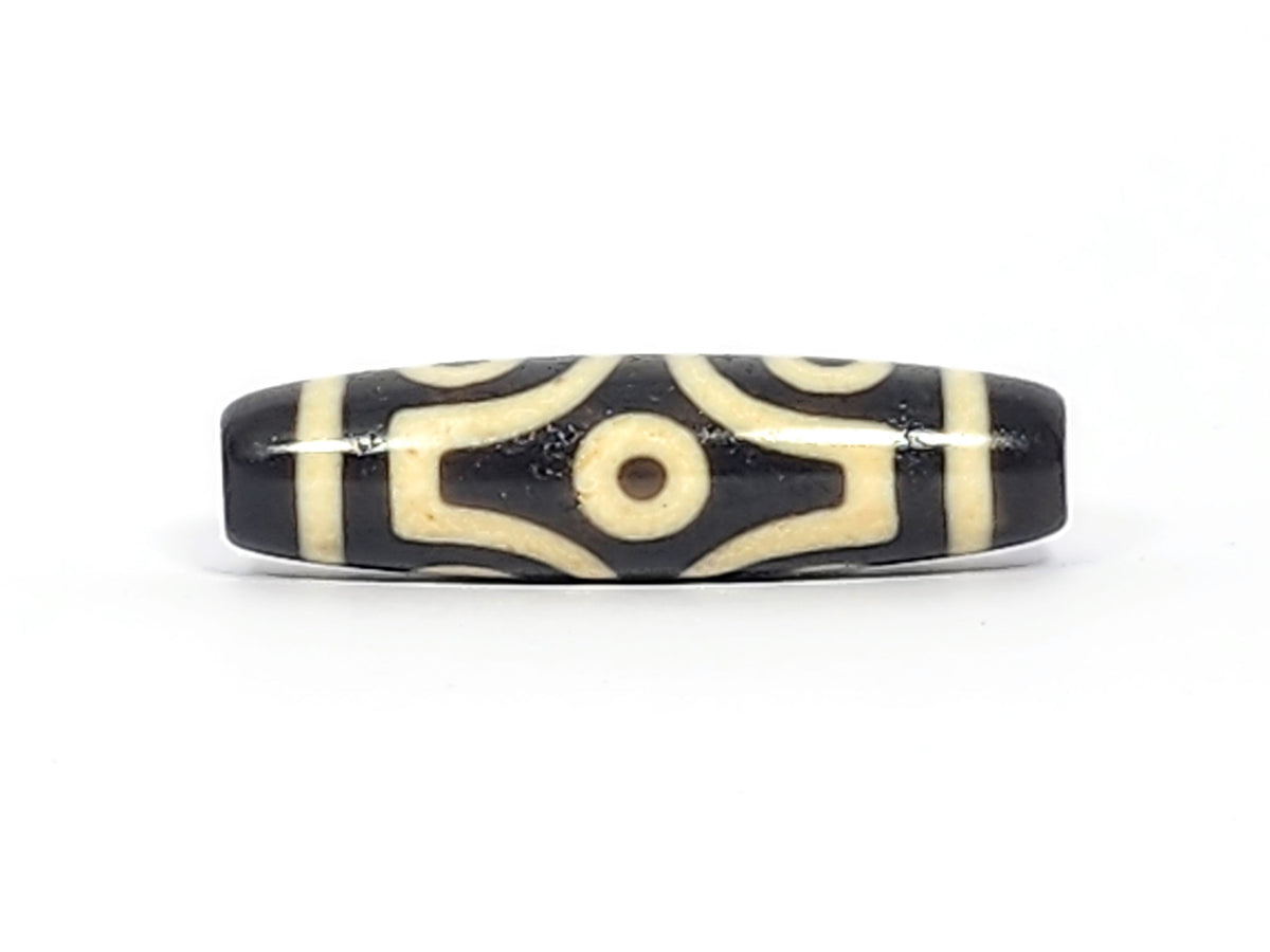 Face C of antique six eye dzi At-042925-6E2, two C-ring eyes with generous scroll arc on pitch-black agate, bold cream motif, paired-eye composition, unretouched