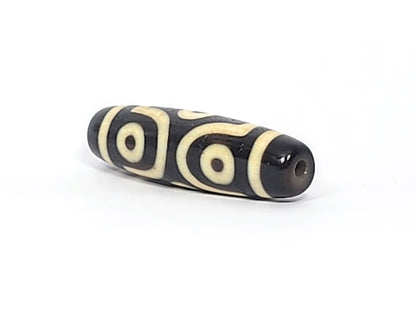 Opposite end cap of antique six eye dzi At-042925-6E2, pitch-black agate tip, drill hole, C-ring eyes and scroll motif visible on body, 41.4mm × 11.4mm, unretouched photography