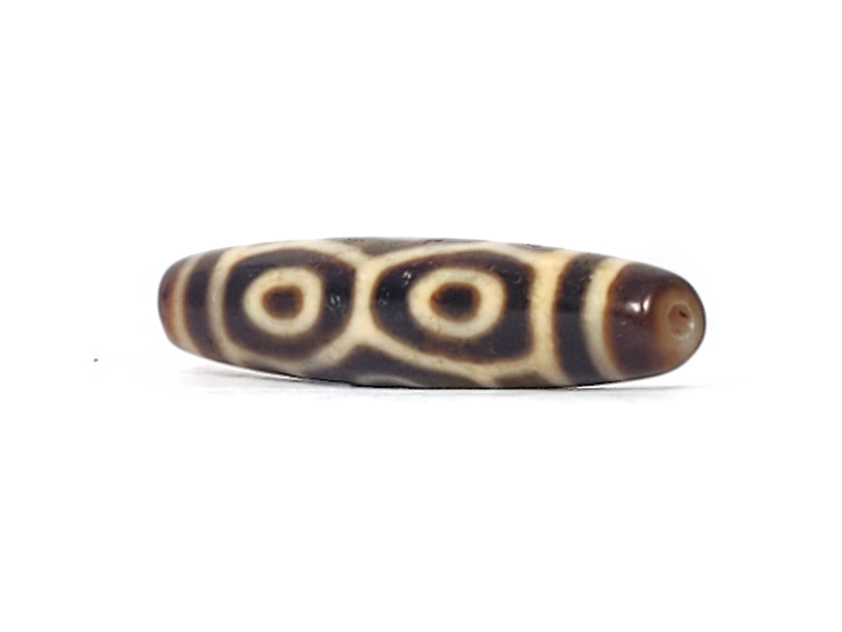 Opposite end of antique Tibetan Naga Dragon Eye dzi bead showing drill hole and paired eye motif, At-092524-6EN