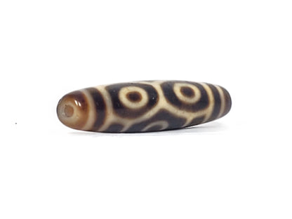Angled end view of antique Naga Dragon Eye dzi bead showing paired eyes and drill hole in dark brown cap, At-092524-6EN