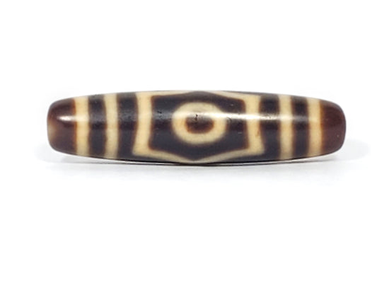 Antique three-eye dzi bead, brown agate, cream white eye motifs, natural patina, elongated barrel shape, visible striping pattern