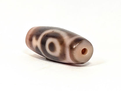 At-061826-2ETV left drill hole end, warm peach-salmon tip, terracotta-orange drill interior, vase motif visible, unretouched