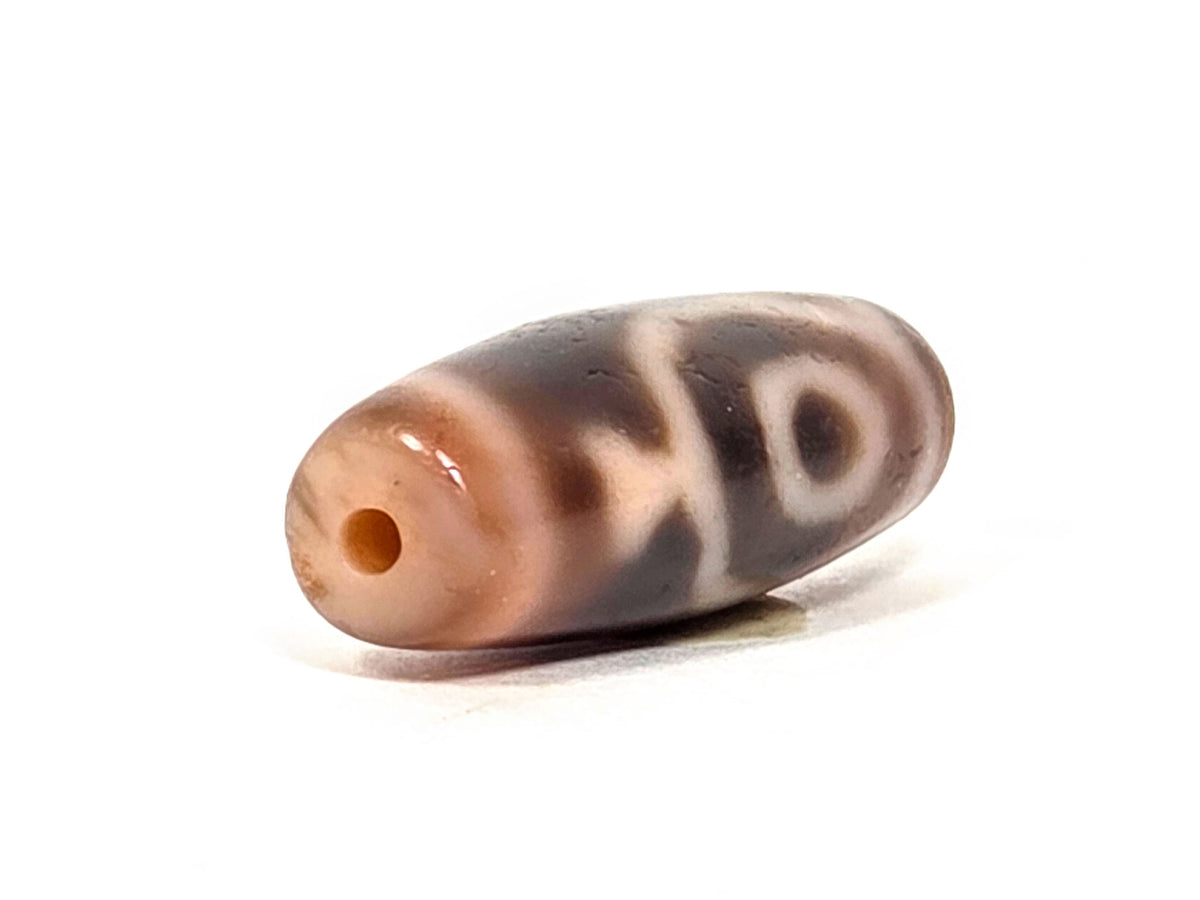 At-061826-2ETV right drill hole end, warm terracotta-orange interior, peach-salmon end cap, translucency visible, unretouched