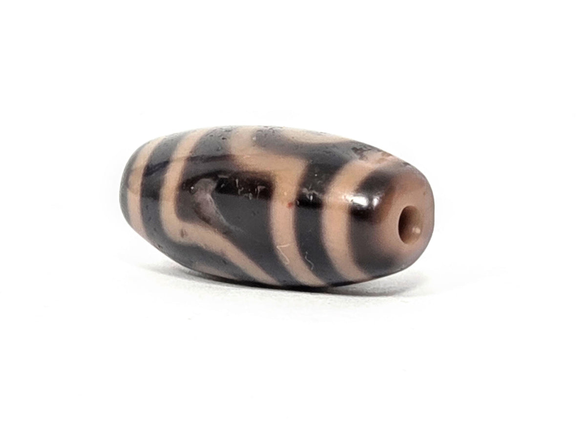 At-033126-2E5, second sandy-cream end cap, drilled hole visible, ovoid body profile, unretouched