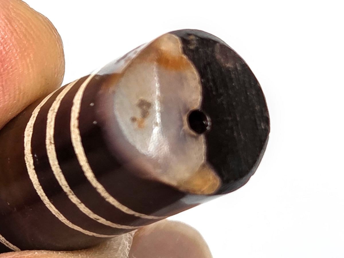 Ac-062226-6Str, macro chipped end, milky-white and orange-brown agate banding exposed, drill hole centred, unretouched