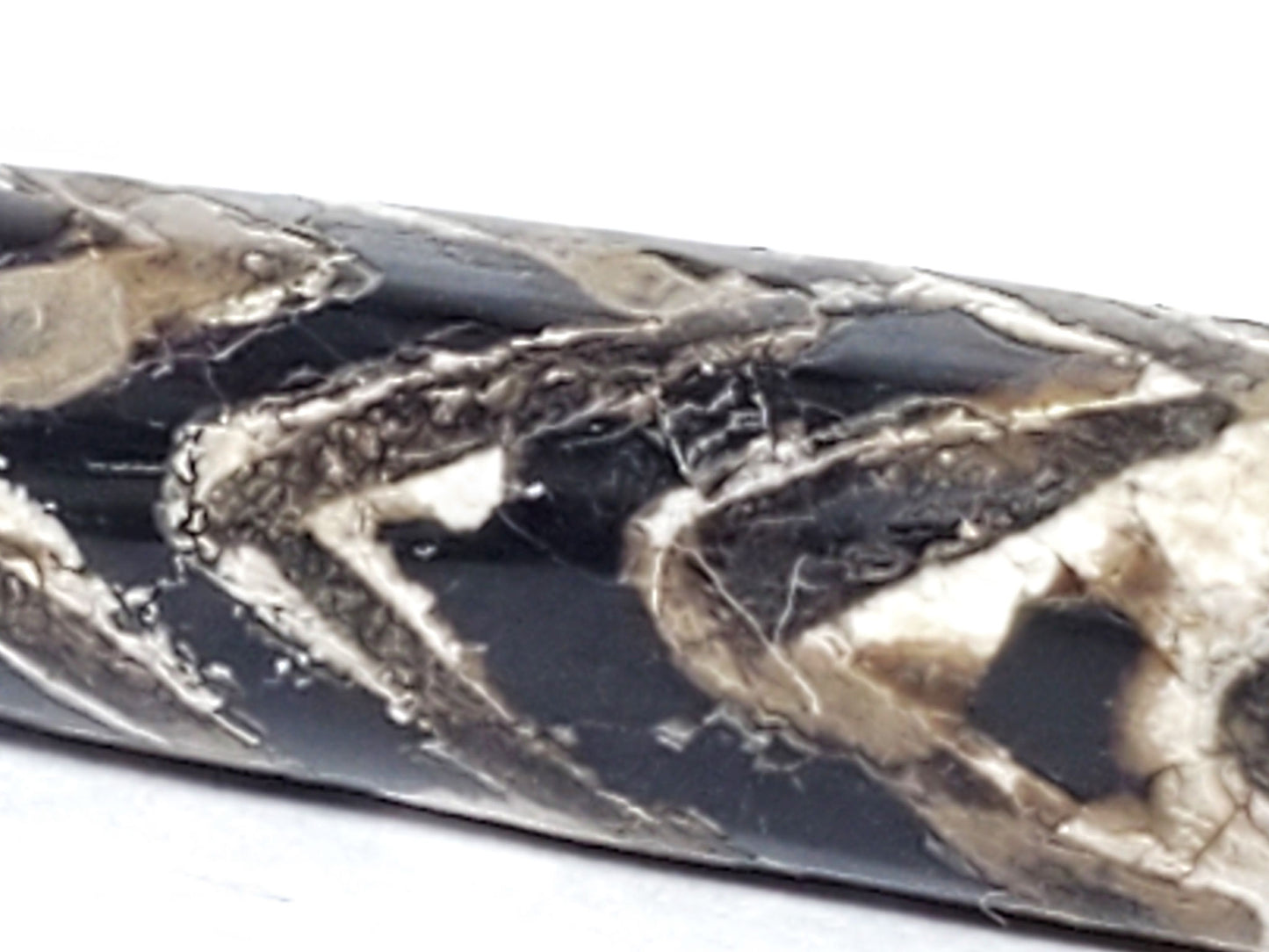 Extreme macro of calcification surface on ancient Four-Row Tiger Tooth Dzi bead — cracked mineral layers over tiger tooth chevron etching, 800–1,000 years of geological accretion
