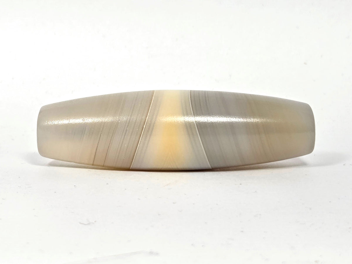 N-N-062126-1E2 dzi bead, angled side view, full band sweep visible, unretouched