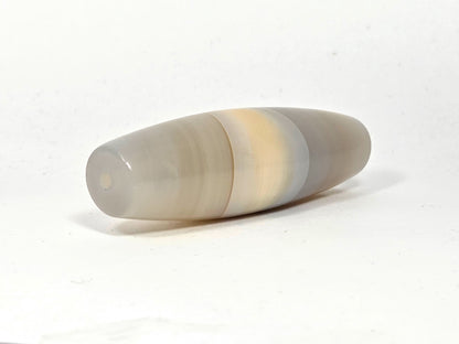 N-N-062126-1E2 dzi bead, three-quarter angle showing tapered end, unretouched