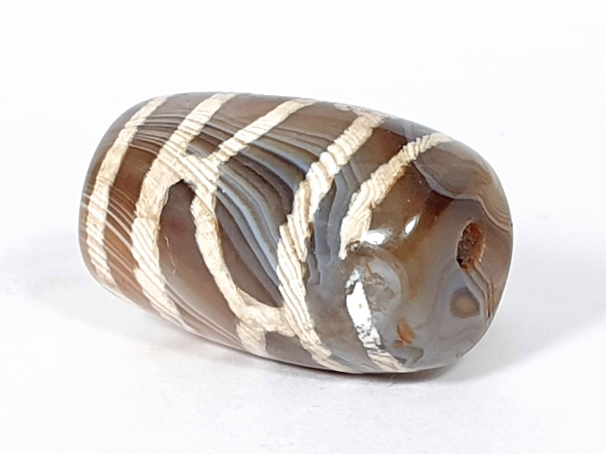 Antique longevity dzi — opposite end angled, drill hole at rounded tip, orange inclusion, agate banding rings, At-0426-Lon2