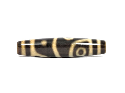 Third face of new four eye variant dzi bead N-102526-4EVS — two cream eyes on opposite edges of the barrel, one low near the left end and one high in a curved frame near the right, separated by a diagonal cream line, dark brown agate, 57.8 mm × 13.2 mm