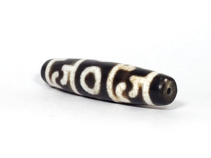 N-062226-GRRP, angled view toward narrow tapered tip, drill hole centred, motif wrapping body, unretouched