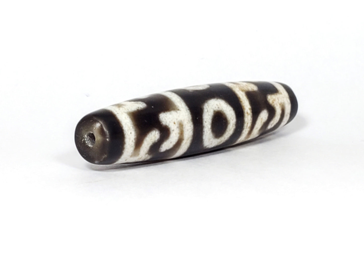 N-062226-GRRP, angled view toward broader end, drill hole centred, continuous motif visible, very dark brown, unretouched