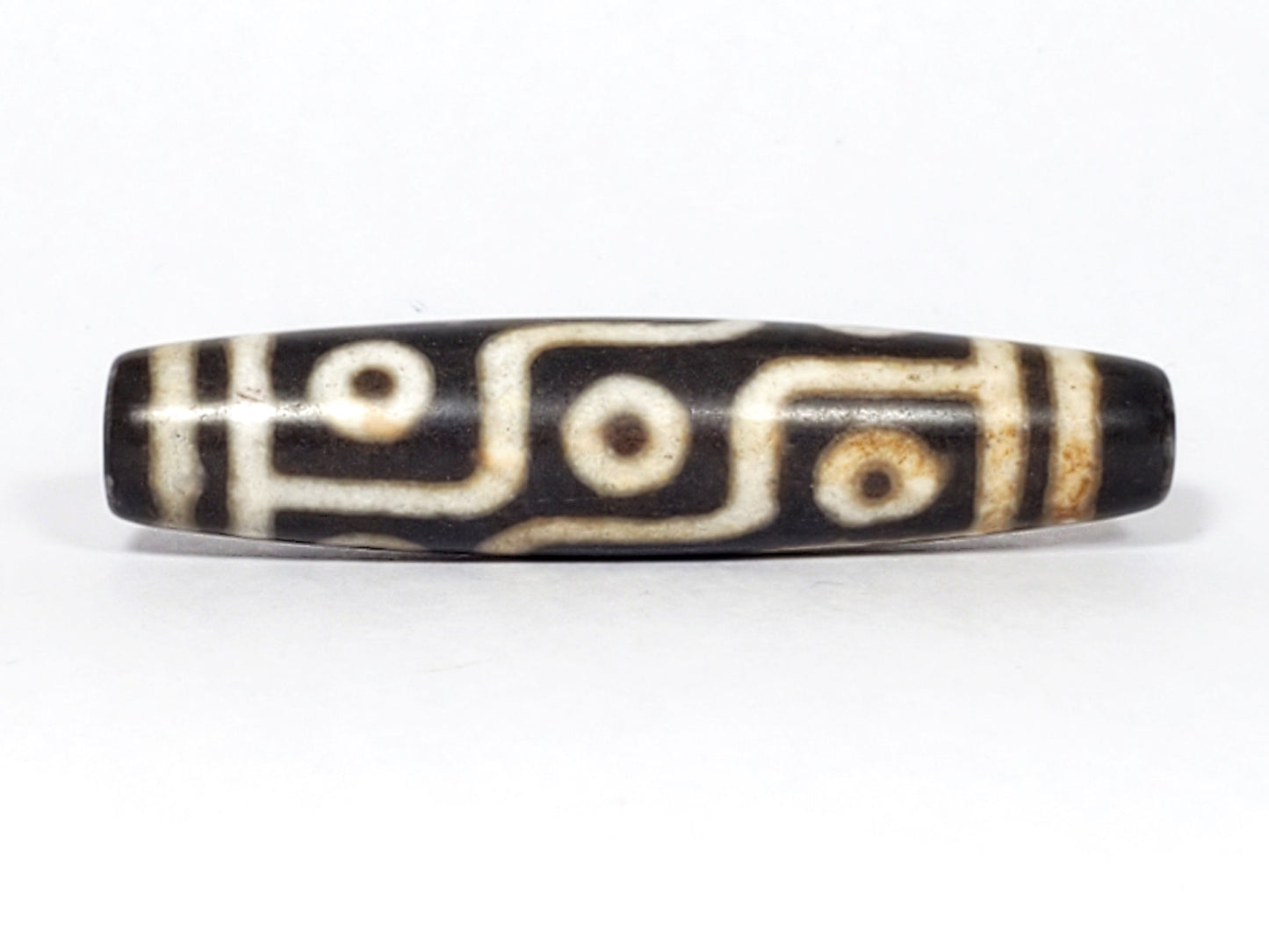 N-062226-9E2, nine eye agate dzi, 57.3×13.0mm, very dark warm brown, warm cream motif, face A, unretouched