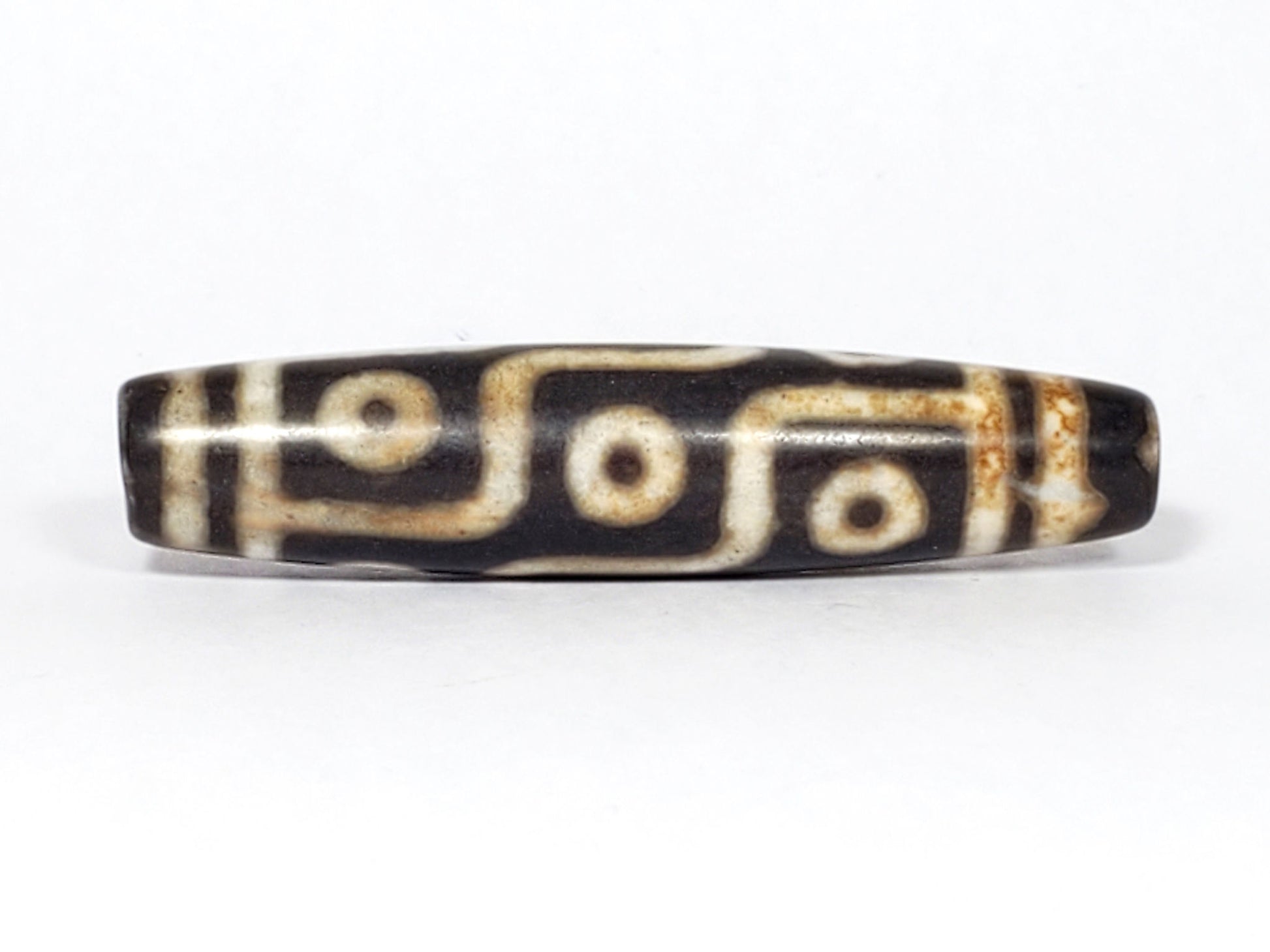 N-062226-9E2, face B, nine eye flowing curved-line motif, dark warm brown ground, warm cream-white lines, unretouched