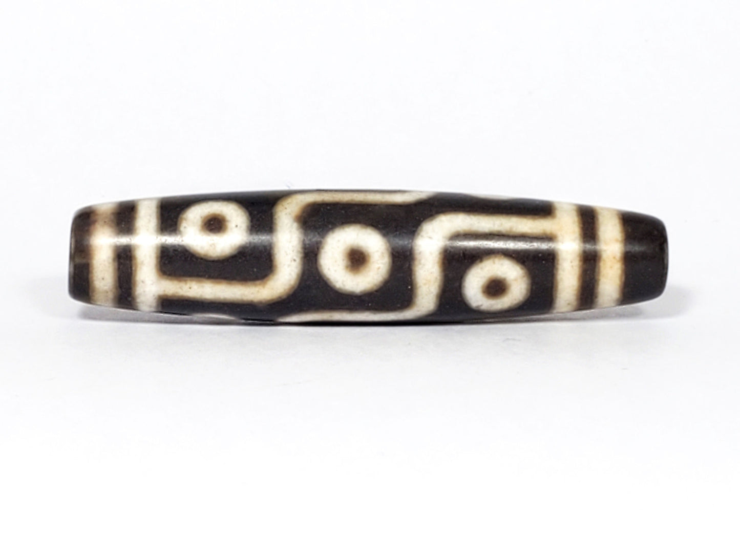 N-062226-9E2, face C, nine eye dzi, very deep dark warm brown, cream motif with honey-tan warmth, unretouched