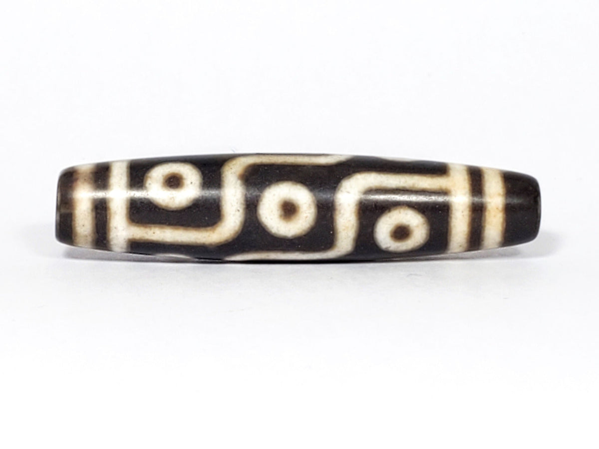 N-062226-9E2, face C, nine eye dzi, very deep dark warm brown, cream motif with honey-tan warmth, unretouched