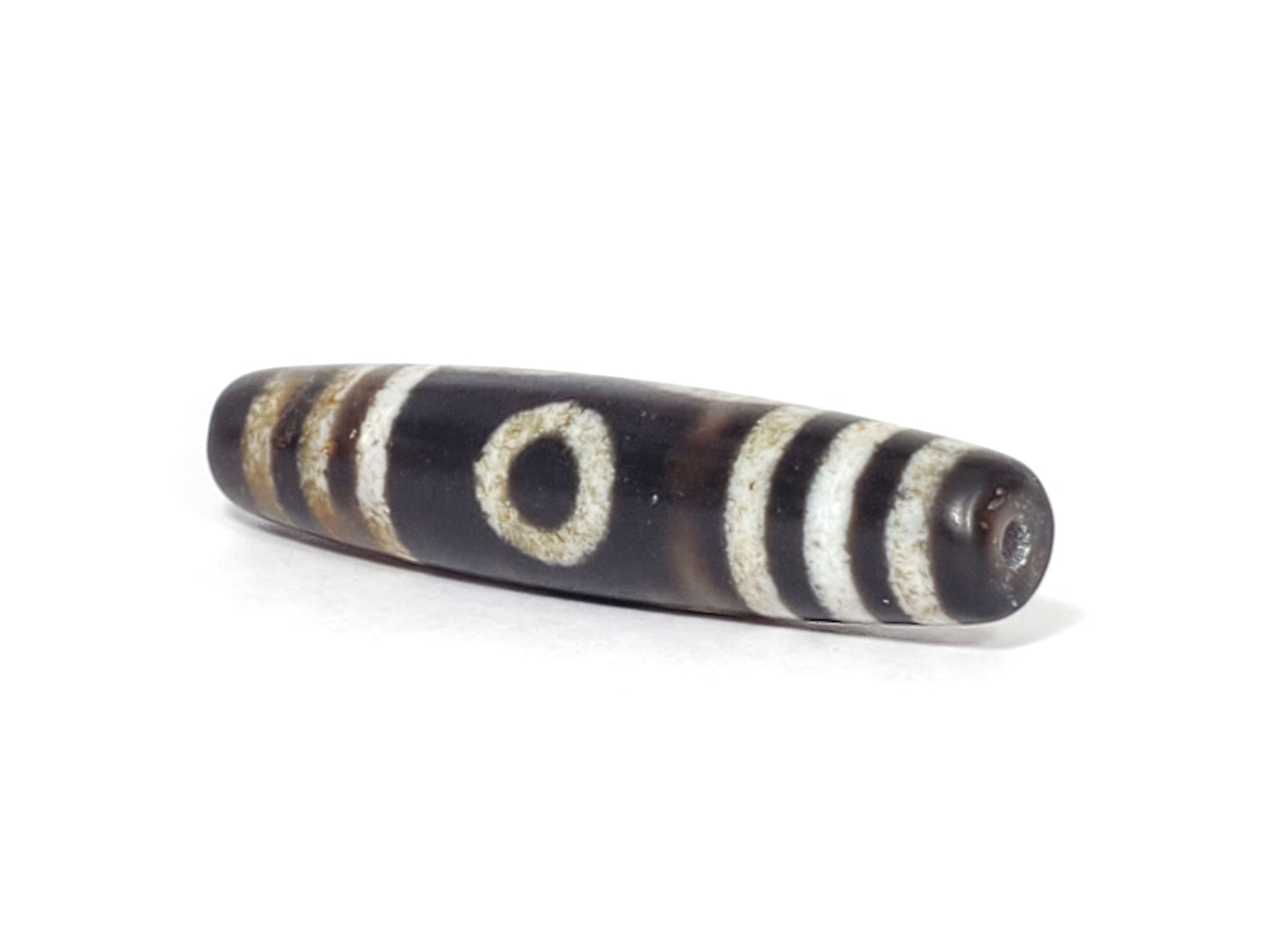 N-062426-3E2 new three eye dzi 57.9x13.3mm angled view narrow pointed end small drill hole near-black tip unretouched