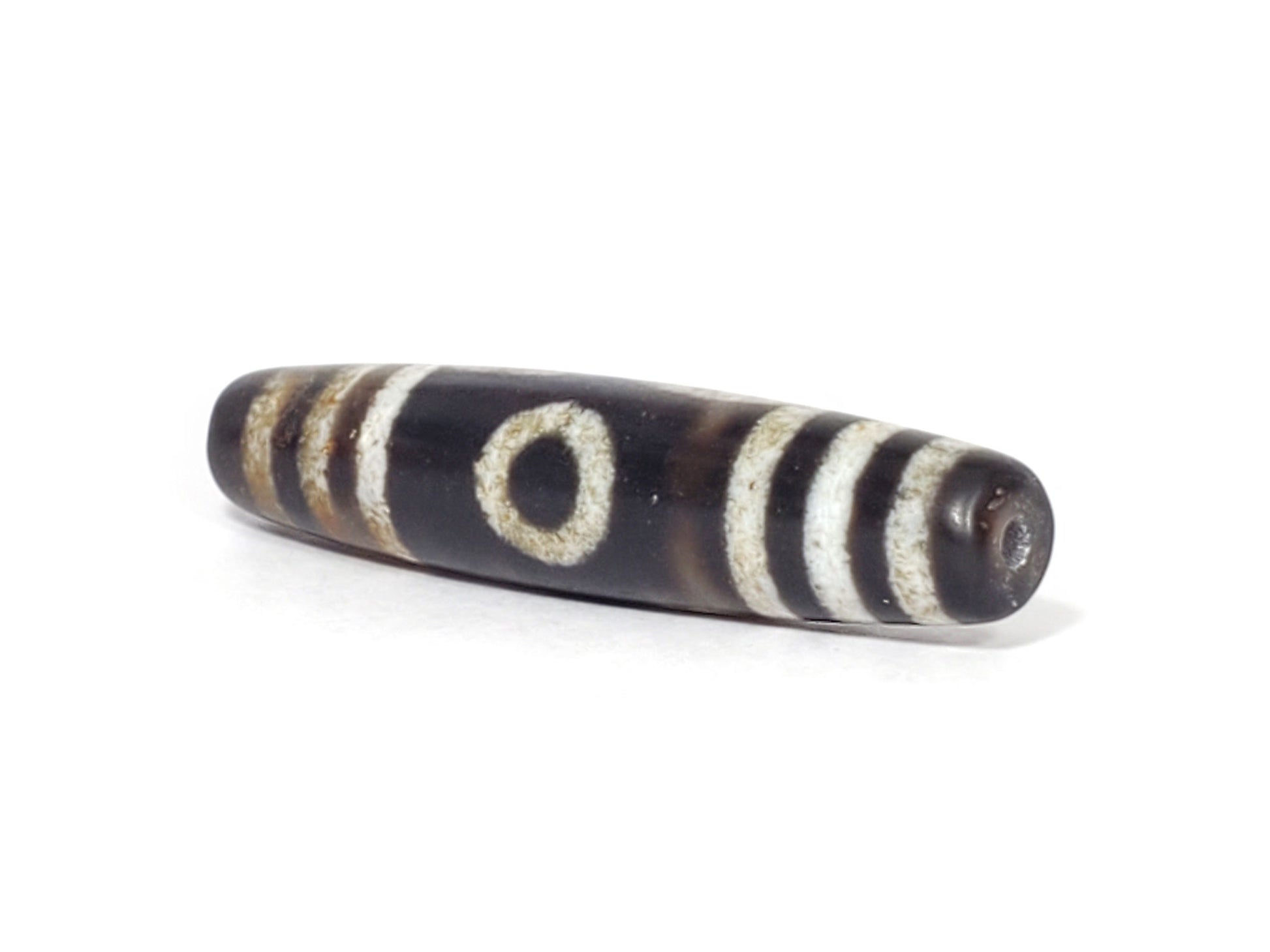 N-062426-3E2 new three eye dzi 57.9x13.3mm angled view narrow pointed end small drill hole near-black tip unretouched