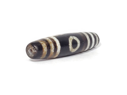 N-062426-3E2 three eye dzi 57.9x13.3mm angled view broader end drill hole warm rust-brown banding near-black unretouched