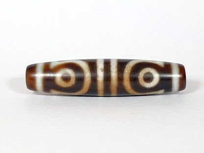 N-062426-4E new four eye dzi 58.5x13.9mm Face A open C-ring and closed ring eyes medium-dark warm brown agate unretouched