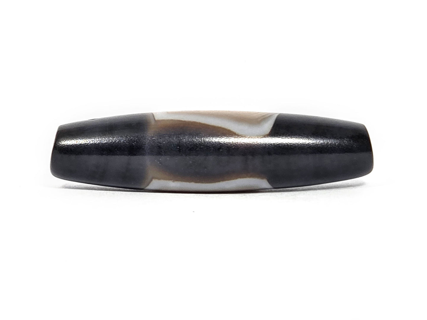 N-N-080426-1E5 natural one eye dzi bead 54.4×14.1mm, turn view showing narrow cream banding arc between pitch-black fields, unretouched