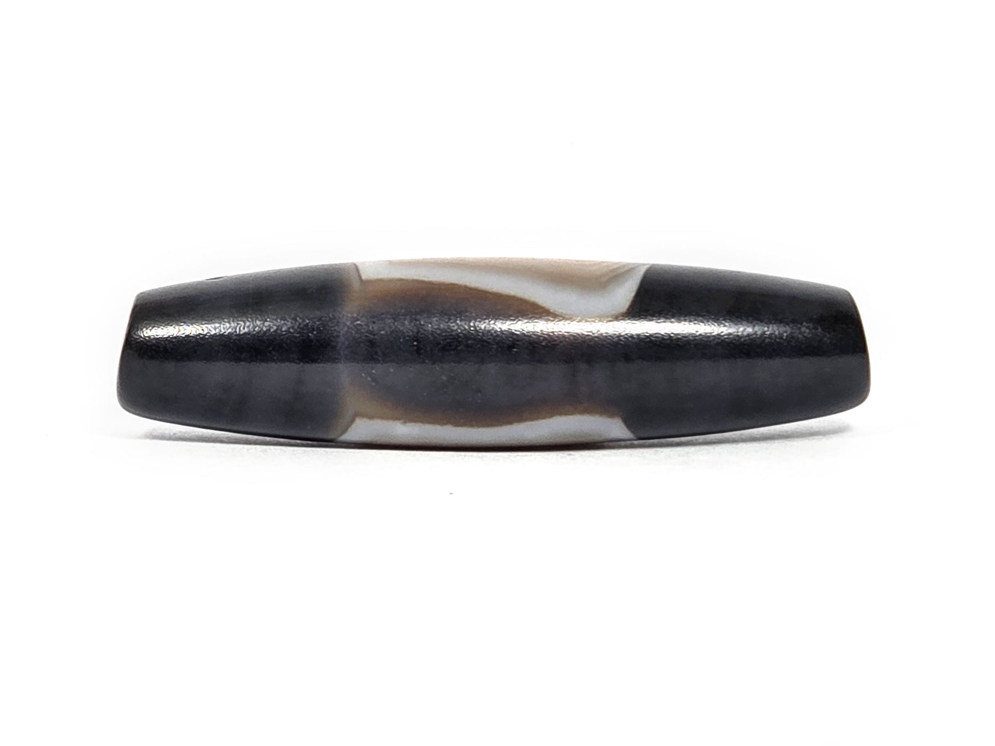 N-N-080426-1E5 natural one eye dzi bead 54.4×14.1mm, turn view showing narrow cream banding arc between pitch-black fields, unretouched
