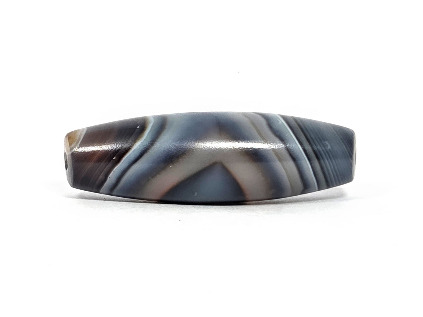 N-N-080926-1E6 natural one eye dzi bead 50.5×15.8mm, opposite turn showing V-chevron banding and warm grey-brown zones in lower register, unretouched