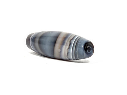 N-N-080926-1E6 natural one eye dzi bead 50.5×15.8mm, opposite angled end view showing secondary naturally-formed eye at drill opening within warm brown oval, unretouched