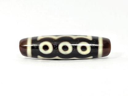 Five-eye dzi bead, dark brown agate, white eye motifs, wave pattern, glossy surface, elongated barrel shape, 41mm