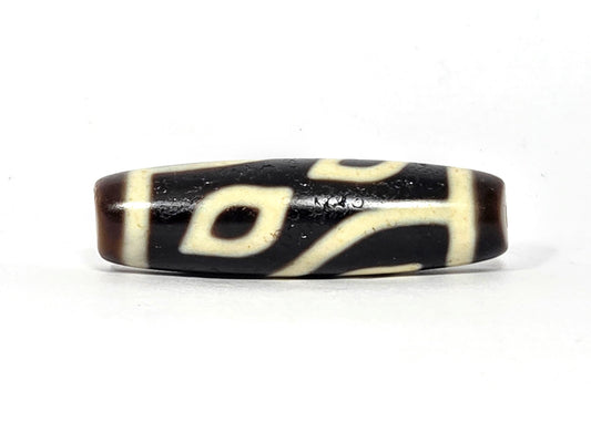 Four-eye dzi bead, dark brown and black agate, cream white eye motifs, wave pattern, aged patina, 40mm barrel shape