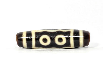 Five-eye dzi bead, very dark brown agate, cream white eye motifs, striped pattern, smooth polished surface, 40.5mm elongated oval shape