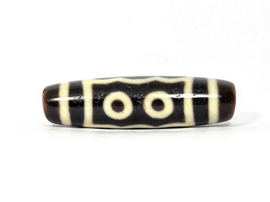 Five-eye dzi bead, very dark brown agate, cream white eye motifs, striped pattern, smooth polished surface, 40.5mm elongated oval shape
