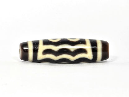 Five-eye dzi bead, dark brown agate, white wave motif, visible drill hole, glossy patina, 40.5×11.4mm