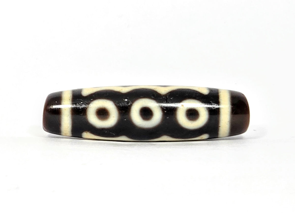 Five-eye dzi bead, dark brown agate, cream eye motifs, vertical stripe pattern, smooth polished surface, 40.5x11mm barrel shape
