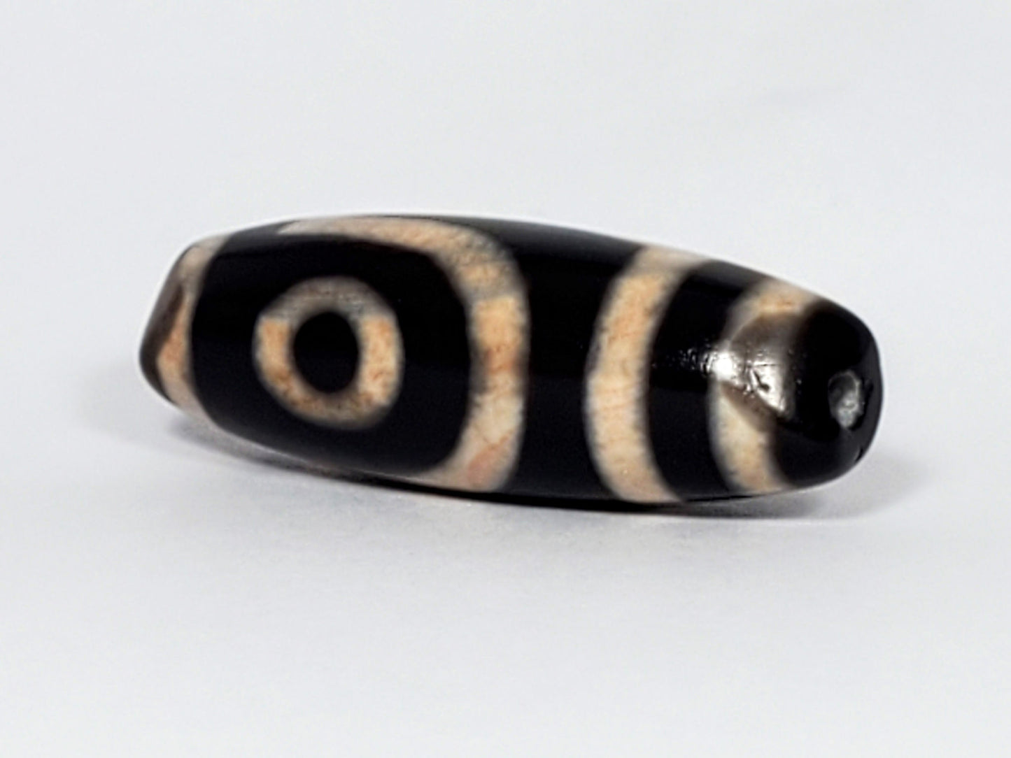 N-062426-2E new two eye dzi 37.7x13.0mm angled view eye face pitch-black tip small drill hole peach-cream unretouched