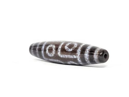 N-062126-6E dzi bead, three-quarter angle showing drilled end, unretouched