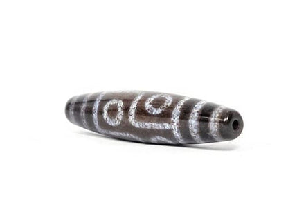N-062126-6E dzi bead, three-quarter angle showing drilled end, unretouched
