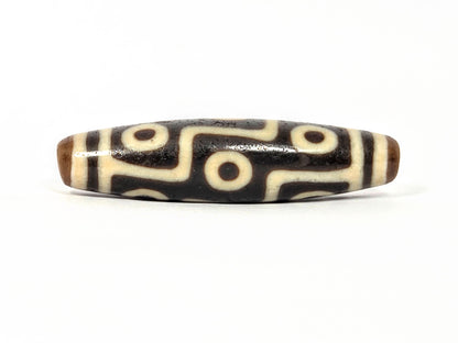 Original ancient Tibetan dzi bead adorned with Nine Eye Pattern in beautiful black and ivory color.