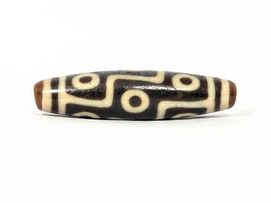 Original ancient Tibetan dzi bead adorned with Nine Eye Pattern in beautiful black and ivory color.