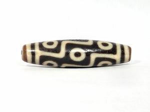 Decorative bead with black and white pattern on a white background