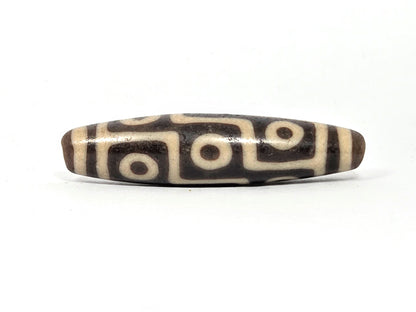 Ac-032326-9E5 ancient nine eye dzi 53.1×12.8mm Face A, warm dark brown ground, broad cream-white eyes, unretouched