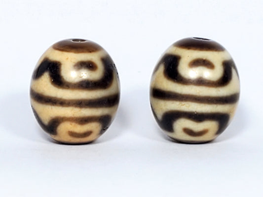Pair of tiger tooth and lotus dzi beads with cream and brown agate banding and drill holes