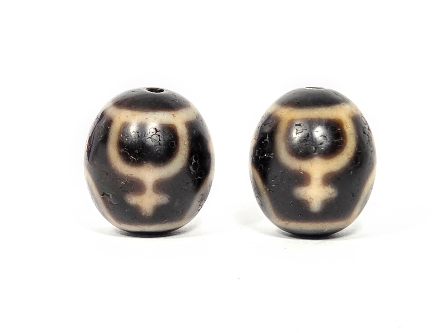 Pair of round Treasure Vase Dzi beads showing four-vase etching pattern on natural agate surface