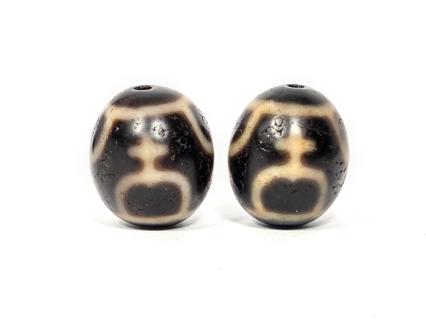 Vintage Taiwan 1980s round dzi bead pair, angled view showing depth of Treasure Vase motif etching