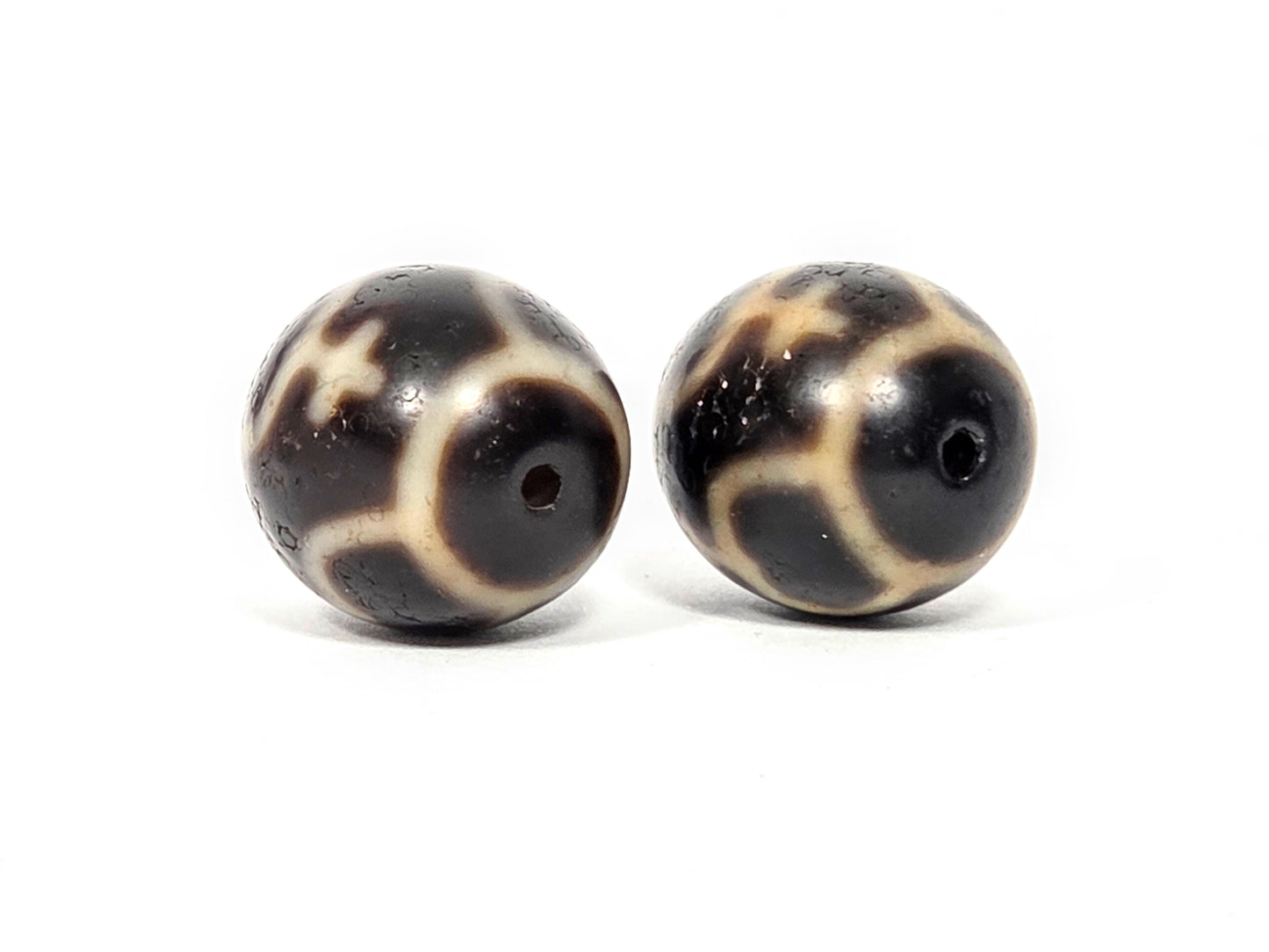 Side profile view of matched pair of round Treasure Vase dzi beads showing spherical shape and agate quality